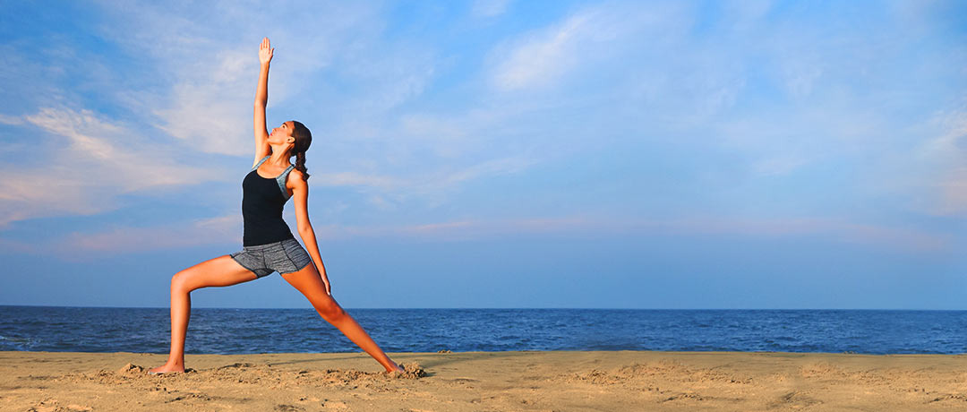 Activewear for everyday movement: a woman practicing yoga by the sea